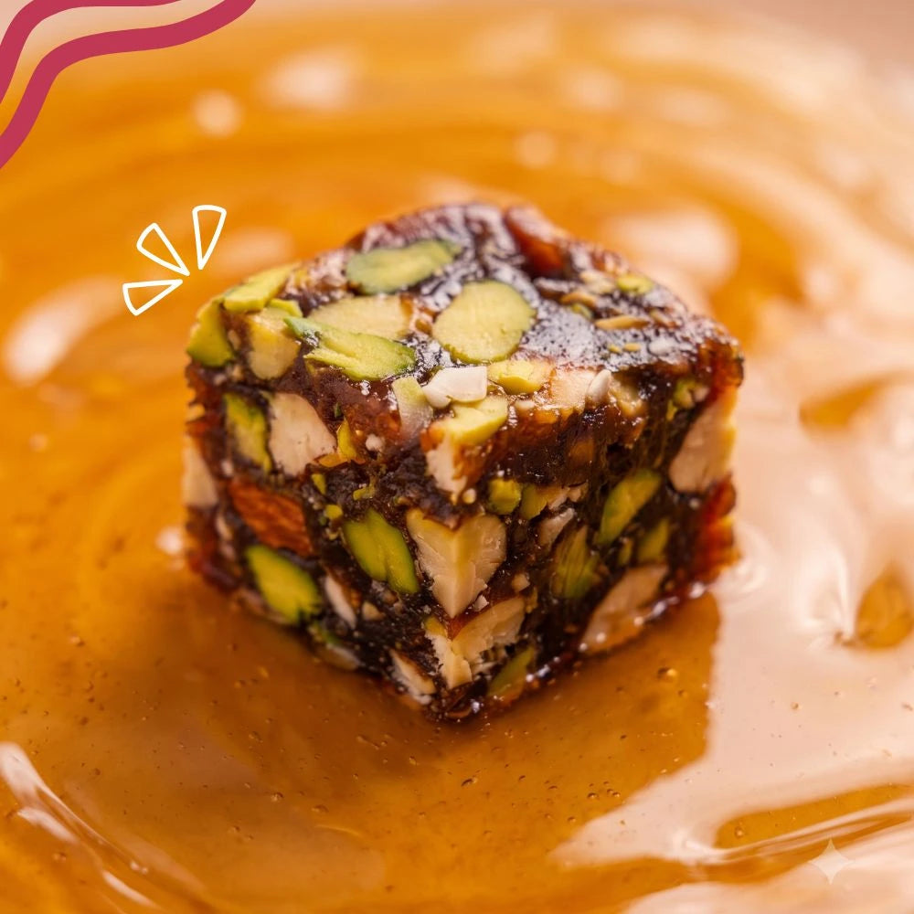 Close-up of a single Mithdi Black Date Bite drizzled with natural honey/syrup.