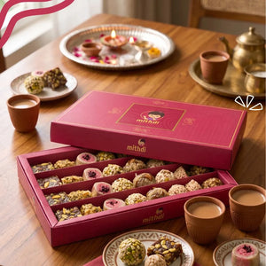Mithdi assorted sweet box arranged on a festive dining table with traditional clay cups and decor