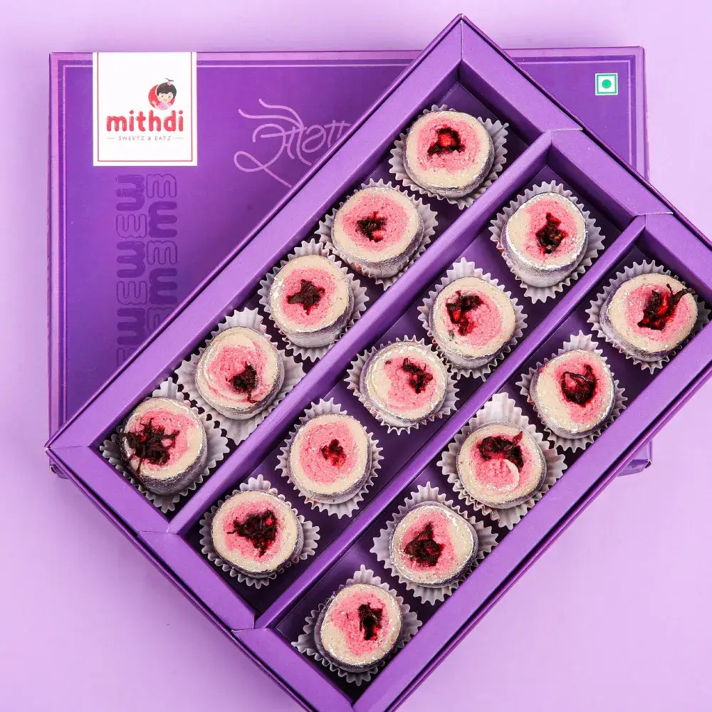 Beautifully arranged pink-centered sweets in a purple gift box, perfect for buy sweets gift online and special occasions in Surat.